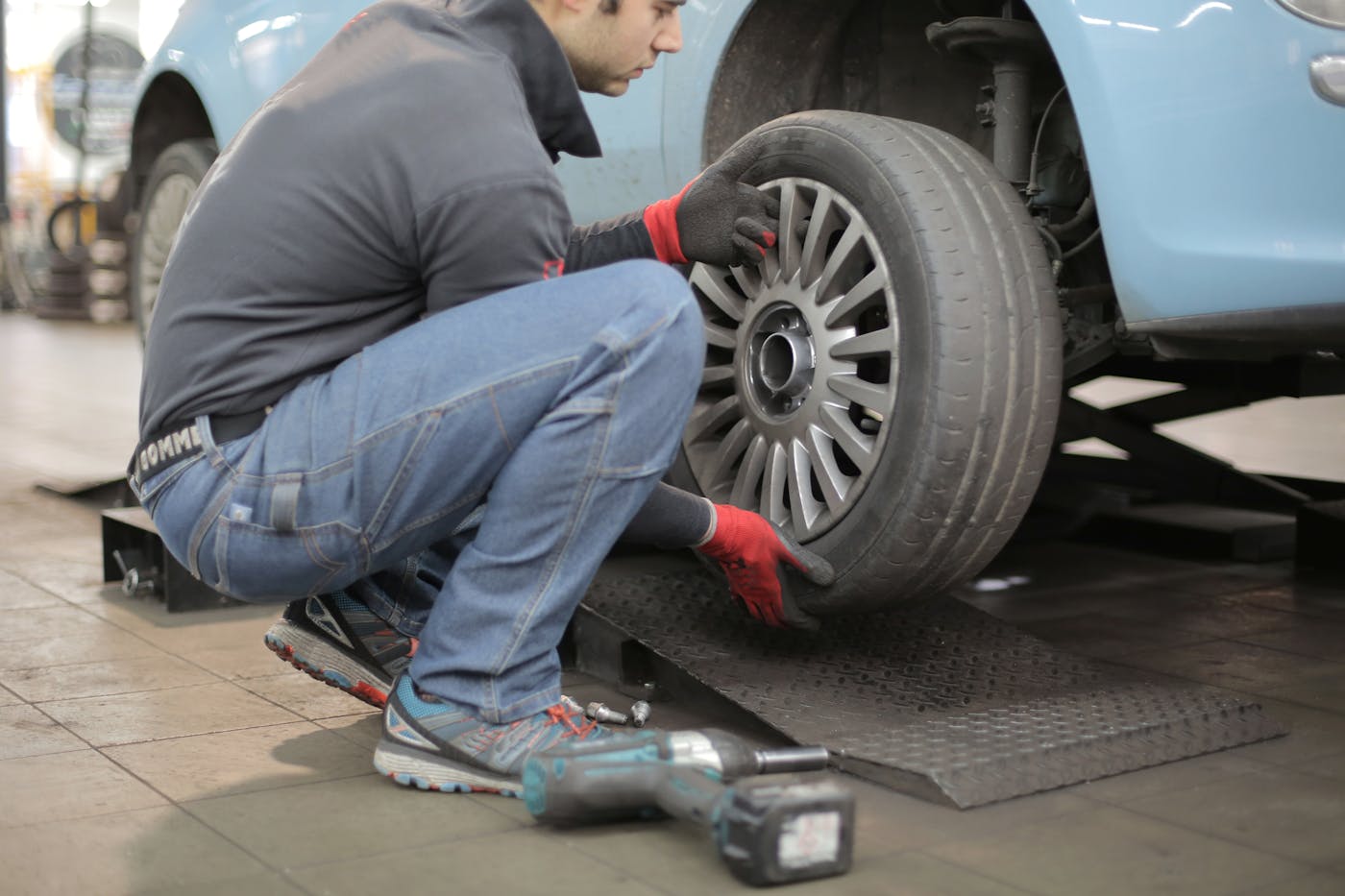 A technician changing a tire in an auto shop